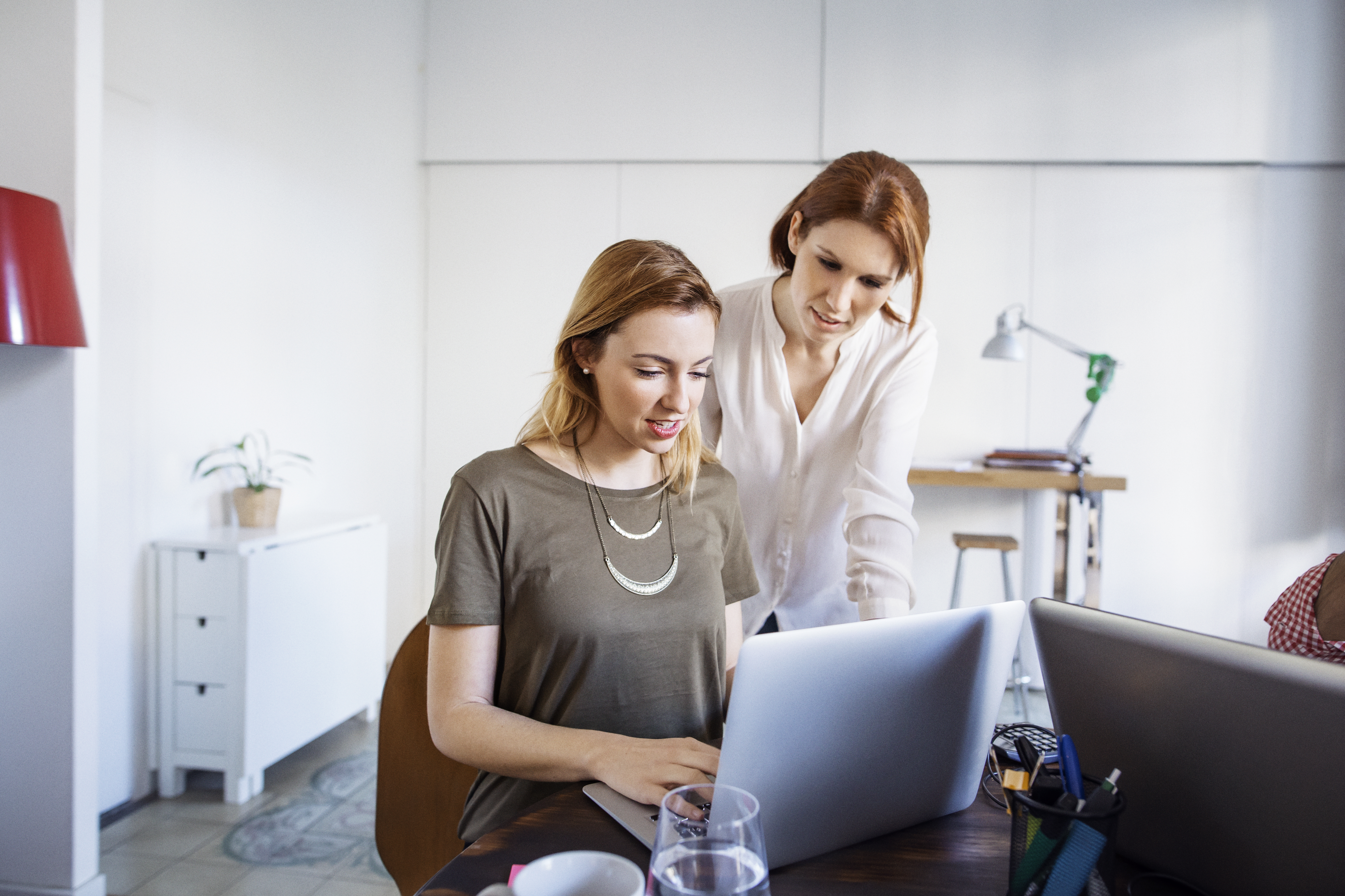 Mujeres empresarias trabajando en ordenador portátil en oficina creativa
