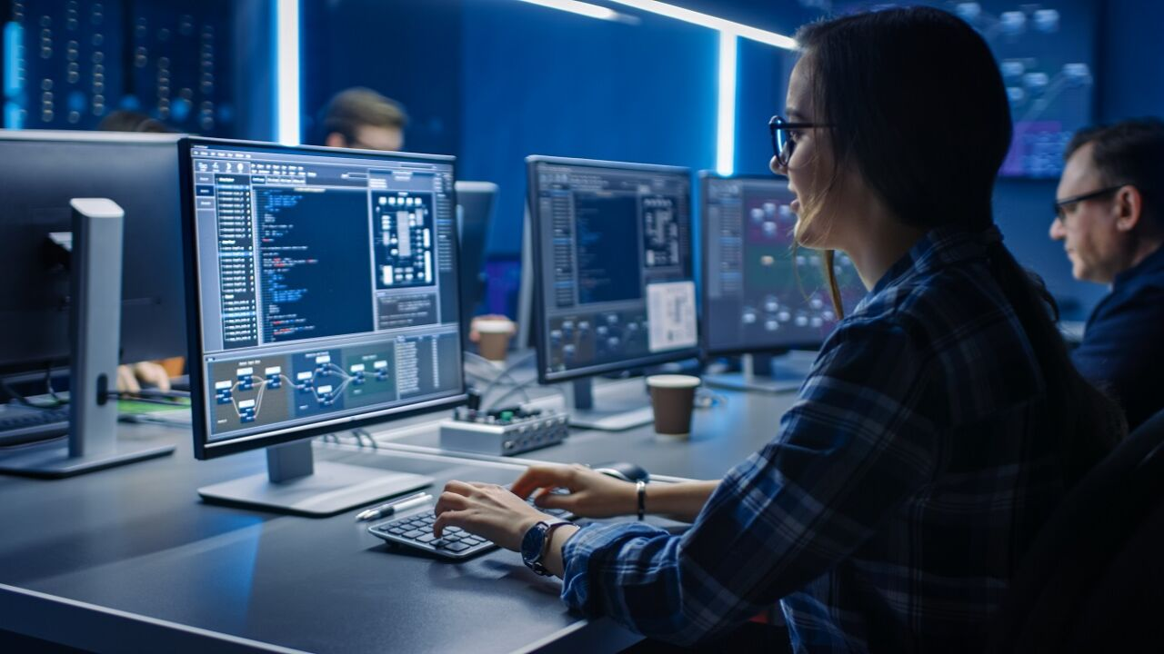Mujer en primer plano frente a pantalla de ordenador en cento de trabajo