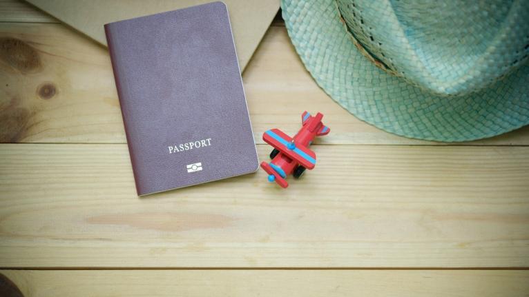 libreta con texto passport y mini avión de madera